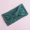 Detail showing soft dark green nylon knotted baby headband on light pink background - Dark Green (17)