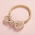 Vue détaillée du nœud en velours côtelé et du bandeau élastique pour bébé - Beige