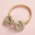 Détail de la texture du nœud en velours côtelé champagne et du bandeau doux pour bébé - Beige
