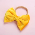 Detailed view of yellow velvet bow headband with soft high-elastic nylon strap for babies - Bright Yellow