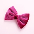 Detailed texture of a magenta velvet bow hair clip for kids on light pink background - Rose Red