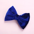 Close-up of a royal blue velvet bow hair clip with a soft texture on a pink background - Sapphire Blue