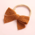 Detailed view of handmade knitted bow and high-elastic nylon headband for infants - Brown