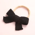 Detailed close-up of soft black knitted bow on stretchable baby headband nylon strap - Black