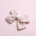 Detail view of pink cotton bow hair clip showing textured fabric and knotted center - Off White