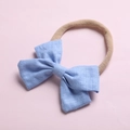 Gros plan sur un bandeau bébé avec nœud bleu clair en lin et nylon élastique doux - Bleu Ciel