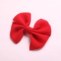 Detailed view of red waffle fabric hair bow clip with textured bubble cloth material - Red