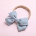 Détail macro du bandeau bébé en nylon doux avec un nœud en coton bleu clair texturé - Bleu Gris