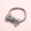 Détail d'un bandeau pour bébé gris clair avec un nœud en nylon doux sur fond rose - Gris