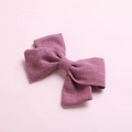 Detail shot of purple slub cotton bow hair clip showing textured fabric on pink background - Dark Purple