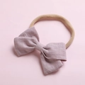 Détail d'un bandeau bébé avec un nœud en lin violet doux et un ruban en nylon - Rose Peau Foncé