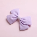 Detailed texture of lavender cotton bow hair clip featuring soft linen fabric weave - Purple