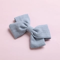 Detail of light blue cotton bow hair clip with textured fabric weave on pink background - Grey Blue