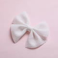 Detailed macro view of a white bubble fabric hair bow clip for infants and kids - White