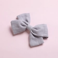 Detail shot of a grey bamboo cotton bow hair clip with textured fabric weave - Light Gray