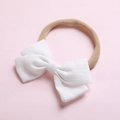 Détail d'un bandeau bébé montrant le nœud en coton blanc et la texture élastique douce - Blanc