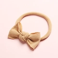 Gros plan du bandeau bébé en nylon souple avec un joli nœud sur fond rose vif - Chair