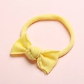 Détail d'un bandeau élastique jaune pour bébé avec un nœud noué à la main en nylon doux - Jaune Poussin