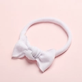 Gros plan d'un bandeau blanc ultra-doux en nylon pour bébé avec un joli nœud - Blanc