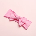 Close-up of pink soft nylon baby headband featuring a delicate bow on a matching background - Water Pink