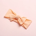 Detail of soft peach nylon waffle knit baby headband with a cute decorative bow - Light Orange