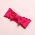Macro detail of elastic nylon baby headband featuring a large magenta textured bow decoration - Rose Red