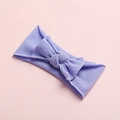 Detail shot of soft purple nylon baby headband with a matching bow on a pink backdrop - Purple