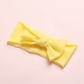 Detail of soft yellow nylon baby headband with a large bow showing breathable knit texture - Chick Yellow
