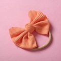 Détail macro du bandeau bébé en nylon corail côtelé avec nœud et élastique souple - Coral Pink (#18)