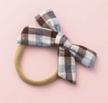 Detail of baby headband featuring a blue and brown plaid bow on soft nylon band - Blue Brown White Large Plaid (#8)