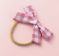 Detailed view of kids checkered pink and white bow elastic hair tie on a pink background - Light Pink White Plaid (#11)