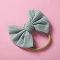 Détail d'un bandeau bébé en maille côtelée vert sauge avec gros nœud et nylon élastique - Licorne & Bonbons