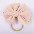 Detail of baby headband featuring soft pink honeycomb textured bow on stretchy nylon band - Light Pink Ribbed Style (#7)