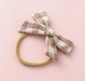 Close-up of baby headband with brown gingham bow on a stretchy khaki nylon band - Brown White Plaid (#5)