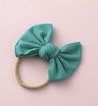 Detail eines petrolfarbenen Strickbogen-Stirnbandes für Babys mit Nylonband - Blaugrün (#1)