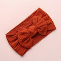 Rust red jacquard nylon baby headband with large bow detail and soft cable knit texture - Orange Red