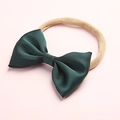 Close-up of a dark green satin bow on a soft nude nylon headband for infants - Dark Green (23)