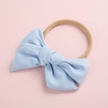 Close-up detail of soft light blue cotton baby headband with bow and elastic nylon band - Sky Blue