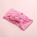 Détail du tissu en nylon rose et du nœud tissé sur ce bandeau à pois pour bébé et enfant - Rose Pâle