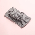 Détail d'un bandeau en nylon gris à pois avec un nœud torsadé et une texture en maille - Gris