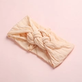 Détail d'un bandeau bébé en nylon abricot doux avec une texture de nœud tressé - Rose Poudré Foncé