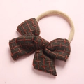 Detailed macro of dark brown linen hair bow with red cross stitching and elastic band - 9-Deep Yellow Plaid