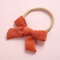 Gros plan d'un nœud en velours côtelé orange sur un bandeau bébé en nylon doux - Orange (15)