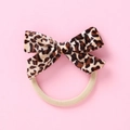 Dettaglio di elastico per capelli con fiocco in velluto leopardato su sfondo rosa - Leopardo Marrone Nero (4)