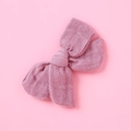 Dettaglio ravvicinato di un fiocco per capelli in mussola rosa con trama intrecciata - Viola Taro
