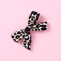 Dettaglio della trama in velluto leopardato su un fiocco per capelli da bambina - Leopardo Classico Giallo Nero (4)