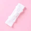 Dettaglio della trama in pizzo bianco e fiocco sulla fascia elastica per neonati - Bianco