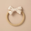 Dettaglio di una fascia morbida beige per neonati con fiocco e motivi a arcobaleno - Stile Stampa Arcobaleno Beige (4)