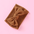 Detailansicht eines karamellfarbenen Strickstirnbands für Babys mit großer Schleife - Braun