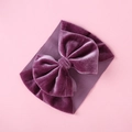 Detailed macro view of deep purple velvet bow with fine texture on elastic headband - Deep purple
